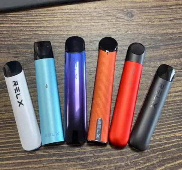 RELX 悅刻五代幻影主機多款配色實拍圖，包含極地白、藍、漸層紫、珊瑚橘等金屬機身。